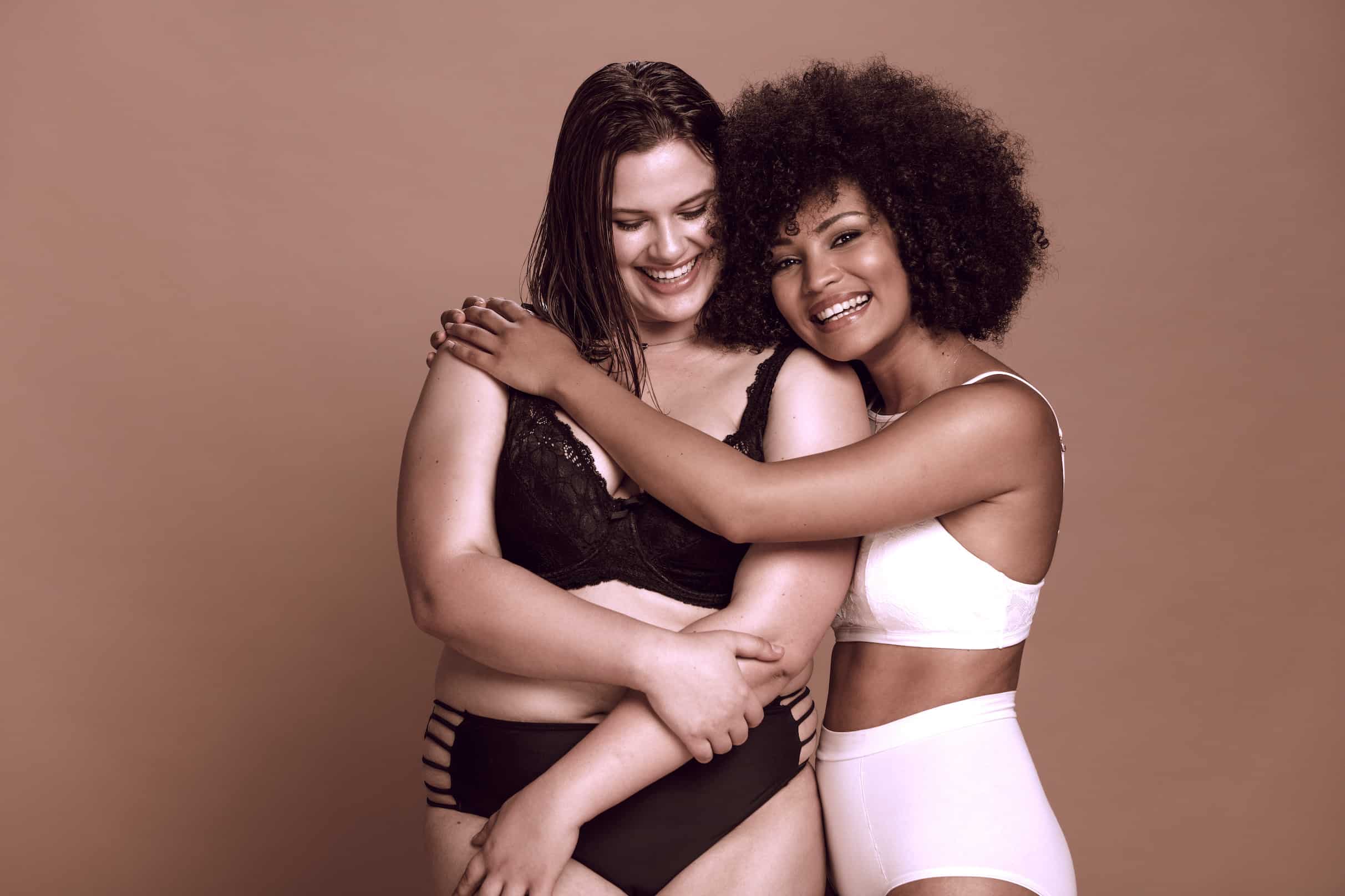 Multi-ethnic females in lingerie standing together